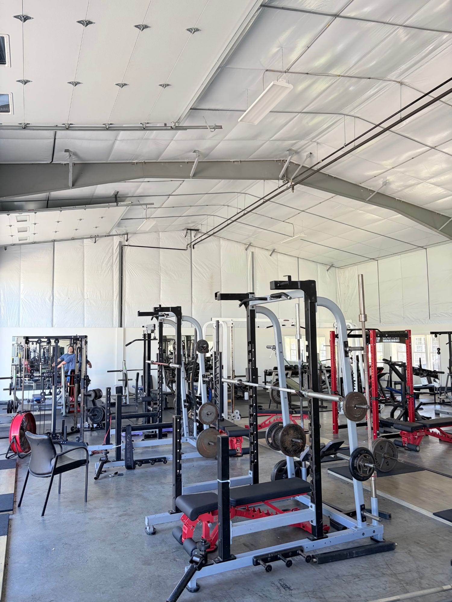 Squat racks, Smith machines and loaded barbells on the free weight floor at Hanley's Gym